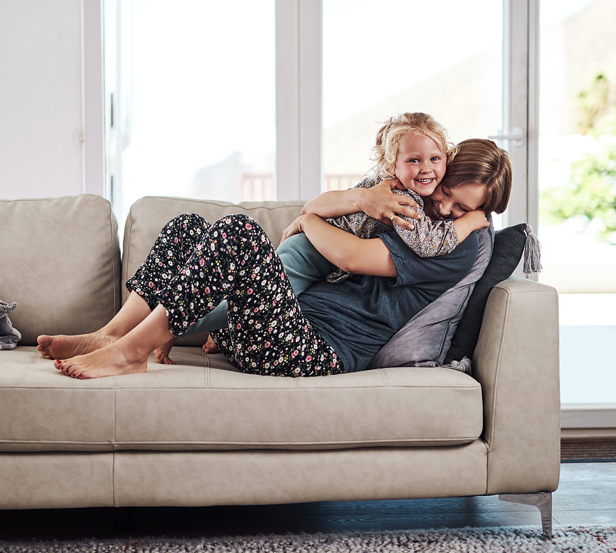 Parent and child smiling together on a sofa